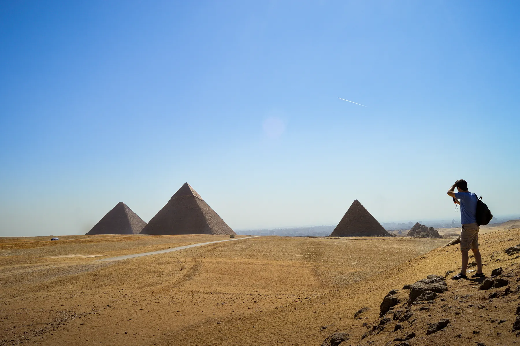 A visitor photographing the Giza pyramid panorama